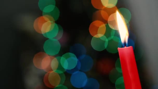 Rode kaars op een donkere achtergrond, Kerstmis kaars op bokeh licht achtergrond, avond van Kerstmis, Nieuwjaar, Kerstmis, gekleurde cirkels, bokeh, close-up — Stockvideo
