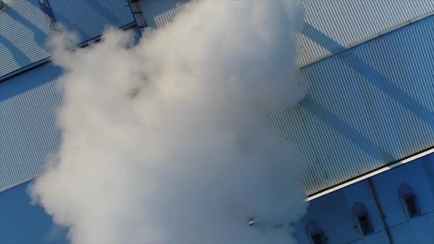 Humo de una tubería en el techo de una fábrica o fábrica, el techo de una sala de producción con una tubería, humo grueso blanco sale de la tubería — Vídeo de stock