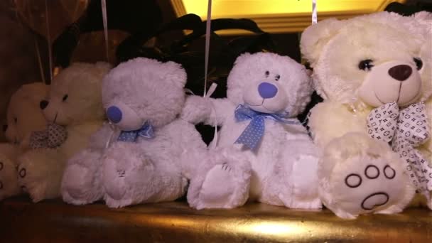 Teddyberen zitten in een rij witte teddy beren, helium ballonnen, schattige teddybeer met een vlinder op haar nek, zacht speelgoed, interieur zalen voor kinderen verjaardag, een geschenk, een kamer, binnenshuis, Teddy bear — Stockvideo