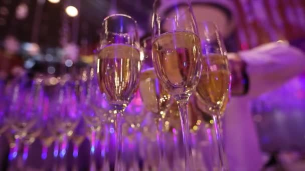 Bril met champagne op de tafel in het restaurant, de glazen champagne op feestelijke tafel, schone glazen op een tafel bereid door de barman voor champagne en wijn — Stockvideo