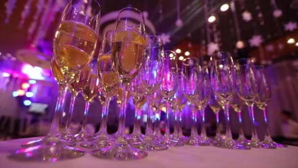 Copos com champanhe na mesa do restaurante, copos de champanhe na mesa festiva, copos limpos em uma mesa preparada pelo barman para champanhe e vinho — Vídeo de Stock