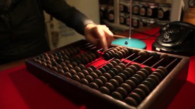 Adam eski telefon, ahşap abacus ofiste arıyor