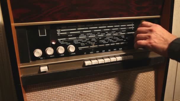 レトロなラジオ男は、古いラジオ受信機、古い受信機の周波数変化の周波数を変更します。 — ストック動画
