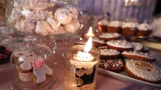 Candy bar in het restaurant, childrens party, verjaardag, een witte teddy beer met een vlinder op haar nek, stak een kaars, teddy bear op een tafel Candy bar, close-up — Stockvideo