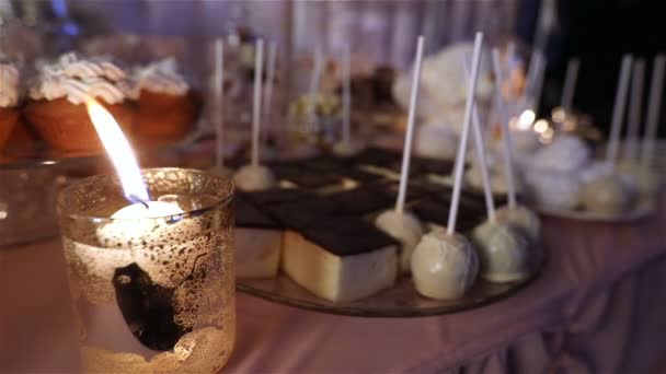 Candy bar in the restaurant, childrens party, birthday, lighted candle, burning candle in a candlestick on a table, Candy bar in the background, Candy bar design of the restaurant, design Candy Bar — Stock Video