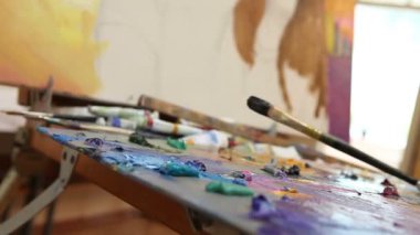 Sanatçı boyalar yağlı boya bir stüdyoda iş yerinde, ressam bir creator parçası sanat, fırçalar ve boya yapar.