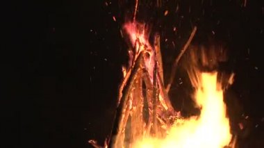 büyük gece şenlik ateşi ormandaki bir açıklıkta karanlık gece gökyüzünde uçan gece yangın kıvılcım