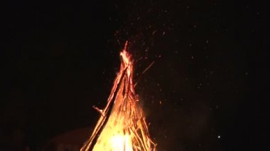 büyük gece şenlik ateşi ormandaki bir açıklıkta karanlık gece gökyüzünde uçan gece yangın kıvılcım