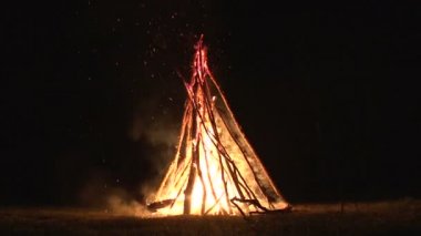büyük gece şenlik ateşi ormandaki bir açıklıkta karanlık gece gökyüzünde uçan gece yangın kıvılcım