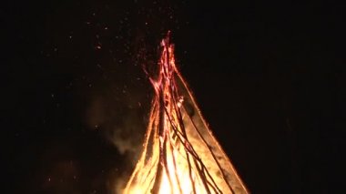 büyük gece şenlik ateşi ormandaki bir açıklıkta karanlık gece gökyüzünde uçan gece yangın kıvılcım