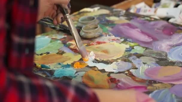 Artista pinta una pintura al óleo en un estudio, pintor en el trabajo, creador hace obra de arte, pinceles y pinturas — Vídeos de Stock