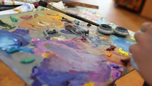 Καλλιτέχνης αναμιγνύει χρώμα στην παλέτα, τέχνη βούρτσα αναμιγνύεται χρώματα στην παλέτα, καλλιτέχνης μίγμα χρώματος πετρελαίου ζωγραφική με το πινέλο στην παλέτα — Αρχείο Βίντεο