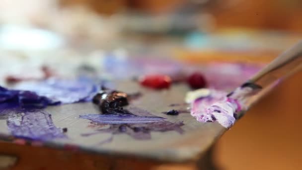 Artist mixes paint on the palette, Art brush mixed paint on the palette, artist brush mix color oil painting on palette, artistic brush, hand close-up — Stock Video