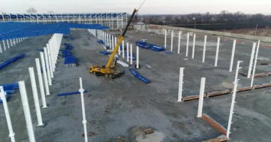 Bir büyük inşaat vinç, modern bir bitki inşaat alanında çalışan insanlar. Vinç metal çerçeve oluşturur