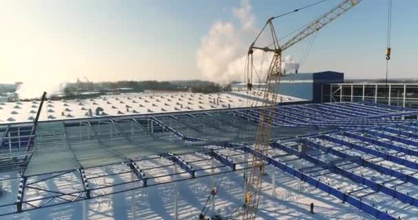 Строительство современного завода или завода, Промышленная зона зимой, панорамный вид с воздуха. Современный завод на заснеженном поле, конструкционная стальная конструкция нового коммерческого здания — стоковое видео