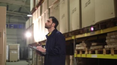 Depo işçisi mal envanterini yapar. Erkek kilerci malları depodaki anlatıyor ve notlar, depo işçisi, sanayi iç, bir ambar iç yapar