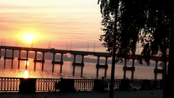 Słońce wschodzi nad rzeką po moście, odbicia wody — Wideo stockowe