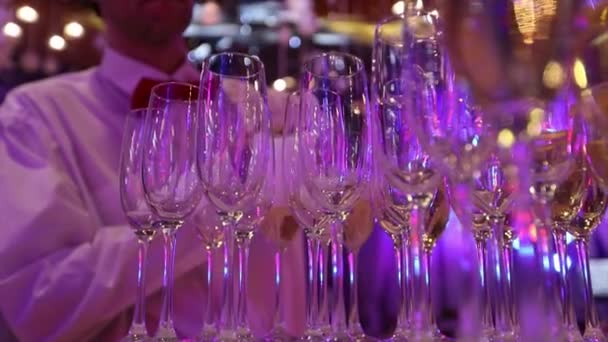 侍者在酒杯里倒香槟, 在餐厅桌上放香槟, 在节日餐桌上喝上香槟, 在桌旁为香槟准备的桌子上有干净的眼镜。 — 图库视频影像