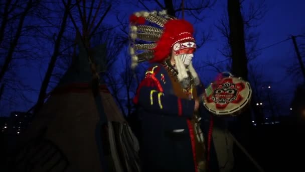 North American Indian v tradičním kroji poblíž lodge, zamračený den, figvam — Stock video