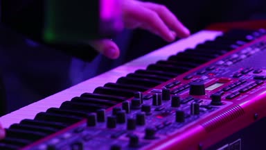 Elektrikli piyano müzisyen Elektrik piyano, klavye synthesizer piyano tuşlarında oynayan aktör. Müzisyen konser Sahne Alanı'nda bir müzik aleti çalıyor. synthesizer