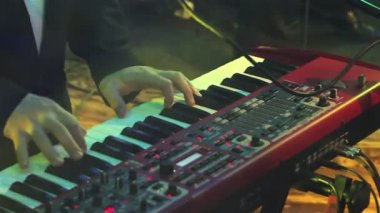 Elektrikli piyano müzisyen Elektrik piyano, klavye synthesizer piyano tuşlarında oynayan aktör. Müzisyen konser Sahne Alanı'nda bir müzik aleti çalıyor. synthesizer