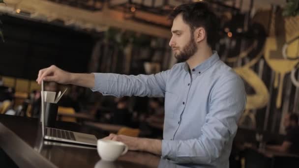 Zakenman met laptop in een café of restaurant, aantrekkelijke mannelijke werknemer computer gebruikt in cafetaria — Stockvideo