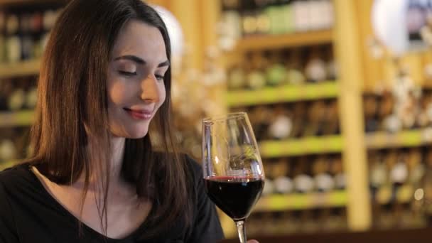 Kvinna med ett glas rött vin, en flicka med ett glas rött vin, en ung vacker flicka dricker rött vin på en restaurang — Stockvideo