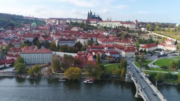 Ein Schiff unter einer Brücke in Prag, im Hintergrund die Prager Burg — Stockvideo