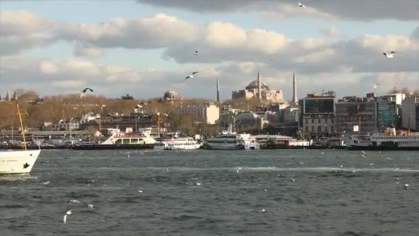 Az idegenforgalmi hajó a Hagia Sophia hátterében hajózik. Törökország, Isztambul. 2019. április 10. — Stock videók