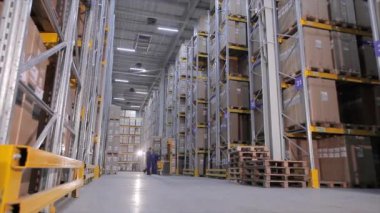 Büyük bir depo işi, iş yerinde depo ekipmanları, büyük bir depoda işçiler.