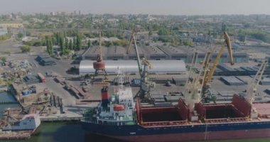 Limanda kuru kargo gemisi var. İskele vinci kargoyu kuru bir kargo gemisine yüklüyor.