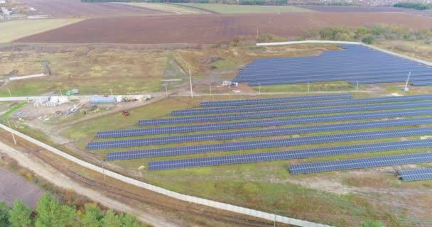 Utsikt över solkraftverk ovanifrån, flygning över ett stort solkraftverk nära skogen — Stockvideo