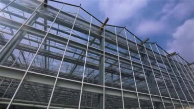 Büyük cam bir seranın manzarası. Dış modern seralar var. Yeni cam seranın görünümü