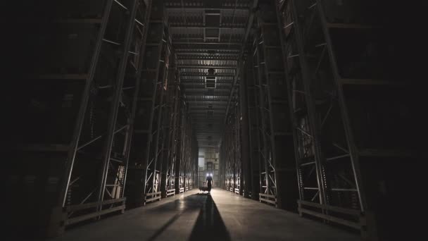 Zu Beginn des Arbeitstages in der Fabrik gehen Männer mit einem Trolley durch das Lager — Stockvideo