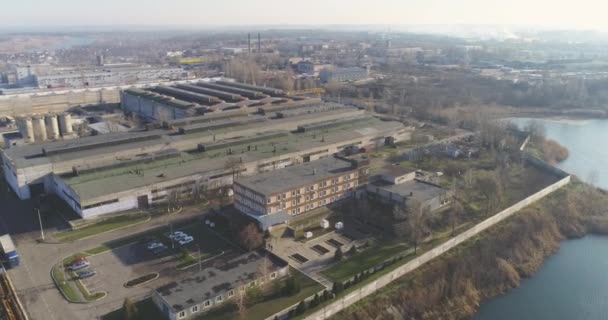 Large plant near the lake, beautiful nature. Industrial buildings top view. Metalwork factory top view. — Stock Video