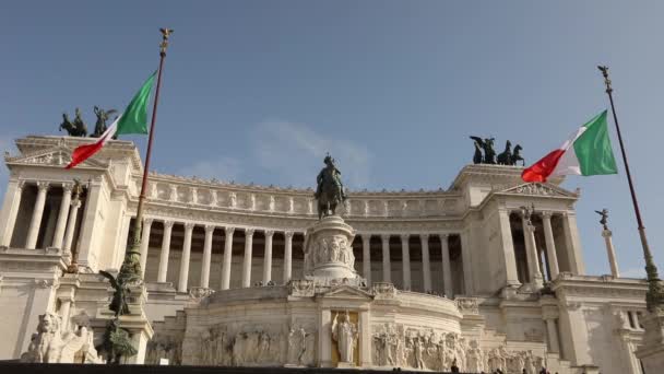 Turistas cerca del Monumento a Víctor Manuel II. Italia banderas cerca del monumento a Victor Emmanuel revoloteando en el viento. Plaza de Venecia en Roma — Vídeos de Stock