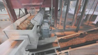 Kum ve metal toplarla taşıma bandı. Fabrikadaki taşıma bandı hattı.