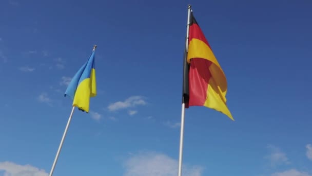 Ukrainska och tyska flagga på himlen bakgrund. — Stockvideo