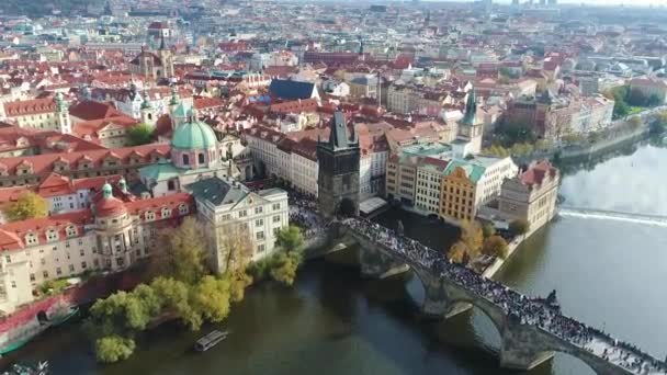 Toeristen wandelen langs de Karelsbrug in Praag, Panoramisch uitzicht van bovenaf, Vltava, vlucht over de Karelsbrug, Praag, 20 oktober 2017 — Stockvideo