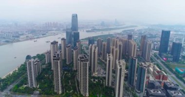 Çin 'in Guachzhou şehrinin üzerinde bir İHA' yla uçuyor, nehrin yanındaki yüksek binaların üzerinden uçuyor.