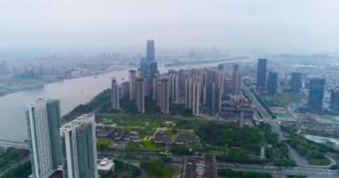 Çin 'in Guachzhou şehrinin üzerinde bir İHA' yla uçuyor, nehrin yanındaki yüksek binaların üzerinden uçuyor.