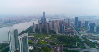 Çin 'in Guachzhou şehrinin üzerinde bir İHA' yla uçuyor, nehrin yanındaki yüksek binaların üzerinden uçuyor.