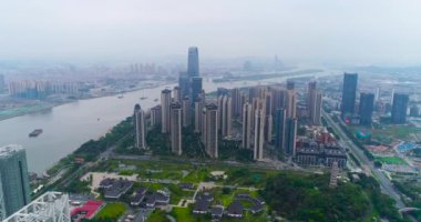 Çin 'in Guachzhou şehrinin üzerinde bir İHA' yla uçuyor, nehrin yanındaki yüksek binaların üzerinden uçuyor.