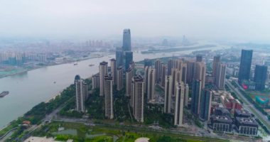 Çin 'in Guachzhou şehrinin üzerinde bir İHA' yla uçuyor, nehrin yanındaki yüksek binaların üzerinden uçuyor.