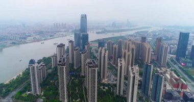 Çin 'in Guachzhou şehrinin üzerinde bir İHA' yla uçuyor, nehrin yanındaki yüksek binaların üzerinden uçuyor.
