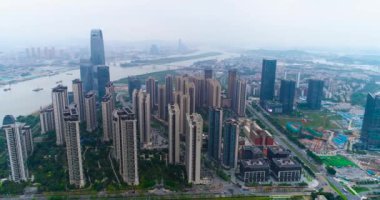 Çin 'in Guachzhou şehrinin üzerinde bir İHA' yla uçuyor, nehrin yanındaki yüksek binaların üzerinden uçuyor.