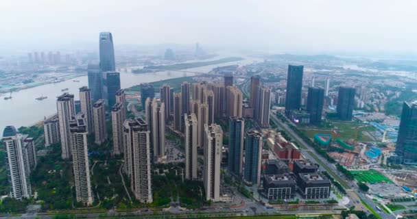 Volando su un drone sopra la grande città cinese di Guachzhou, sorvolando alti edifici vicino al fiume — Video Stock