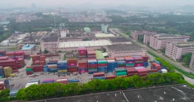 Büyük bir girişimin yakınındaki bir depoda birçok konteynır var. Stok görüntüsünde çok renkli konteynırlar