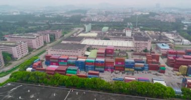 Nakliye konteynırlarıyla dolu büyük bir deponun üzerinden uçacağız. Nakliye konteynırları hava manzaralı büyük bir depo.