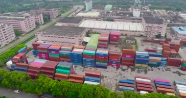 Nakliye konteynırlarıyla dolu büyük bir deponun üzerinden uçacağız. Nakliye konteynırları hava manzaralı büyük bir depo.